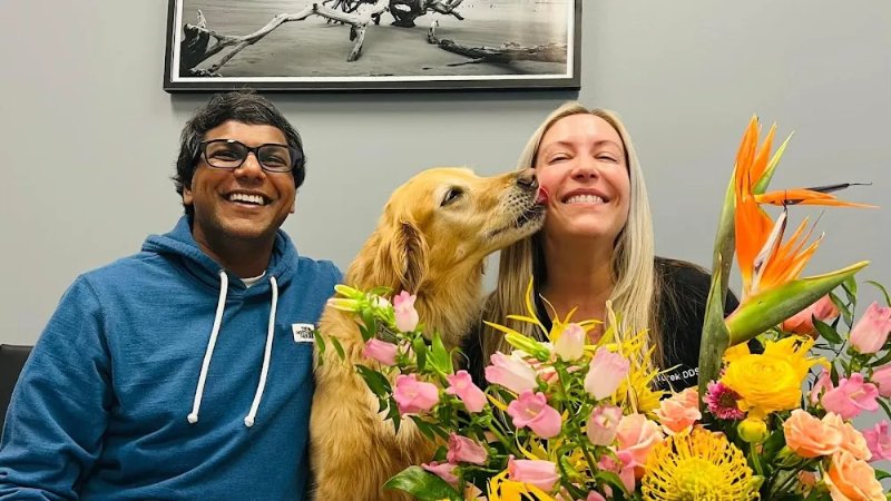 Dr. Prasad Vasamsetti and Dr. Jenny Turek of Driftwood Dental Studio in Wilmington, NC with Abby, the office therapy dog
